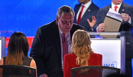 Former New Jersey Gov. Chris Christie speaks to moderator Megyn Kelly during a break in the fourth Republican presidential primary debate at the University of Alabama in Tuscaloosa, Alabama, on Wednesday.