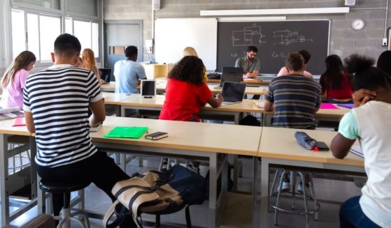 A stock photo shows high school students in a classroom.