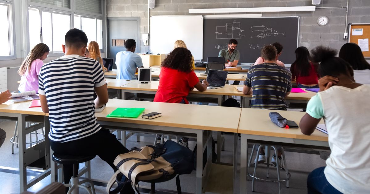 A stock photo shows high school students in a classroom.