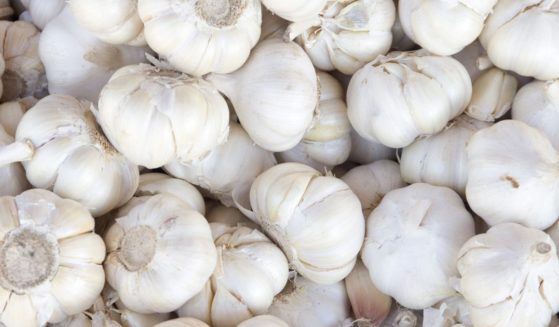 A stock photo shows a pile of white garlic.