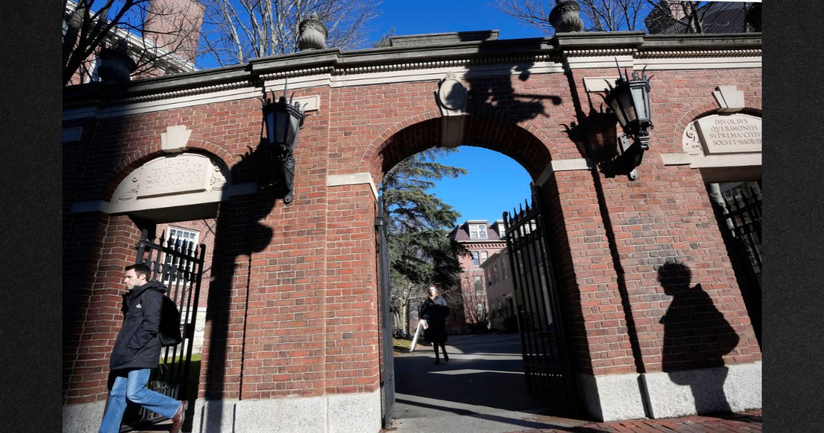 Passers-by walk near an entrance to Harvard University, in Cambridge, Massachusetts Dec. 12. The Ivy League school saw a sharp decline in applicants for early admission for 2024 in the wake of scandals involving anti-Semitism and plagiarism.
