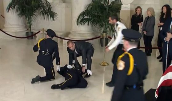 An officer collapses while serving as part of the honor guard for former Supreme Court Justice Sandra Day O'Connor at the Supreme Court in Washington on Monday.