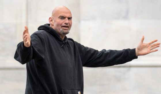 Sen. John Fetterman gestures to reporters as he arrives at the U.S. Capitol on April 17 in Washington, D.C.