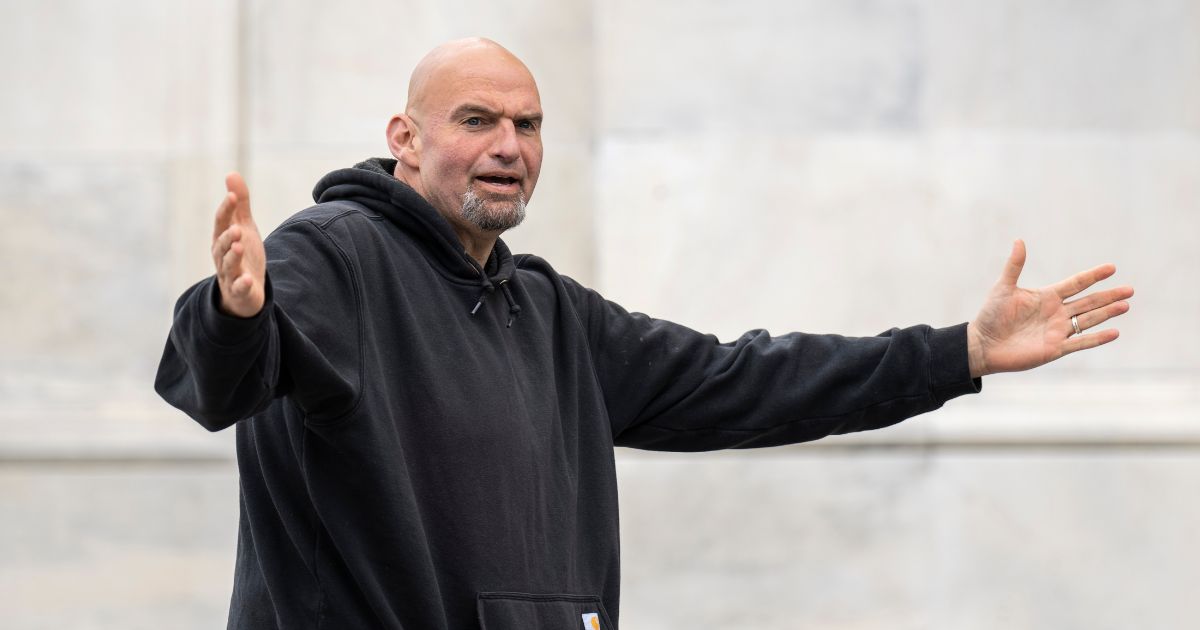 Sen. John Fetterman gestures to reporters as he arrives at the U.S. Capitol on April 17 in Washington, D.C.