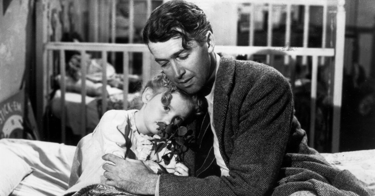 Actor Jimmy Stewart, right, hugs actor Karolyn Grime, left, while filming "It's a Wonderful Life."