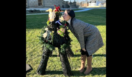 Samantha Skorka kisses a satanic display at the Michigan state Capitol in Lansing.