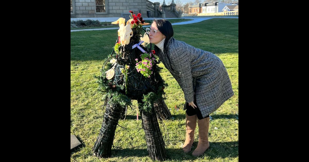 Samantha Skorka kisses a satanic display at the Michigan state Capitol in Lansing.