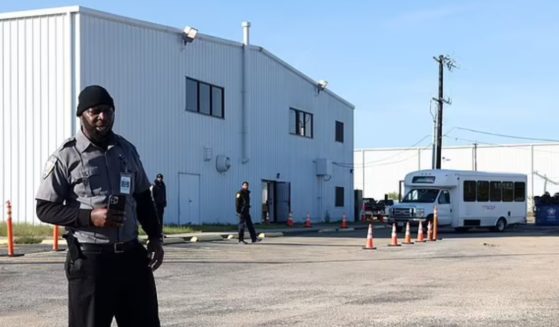 A security guard stands near a San Antonio airport hangar that houses illegal immigrants.