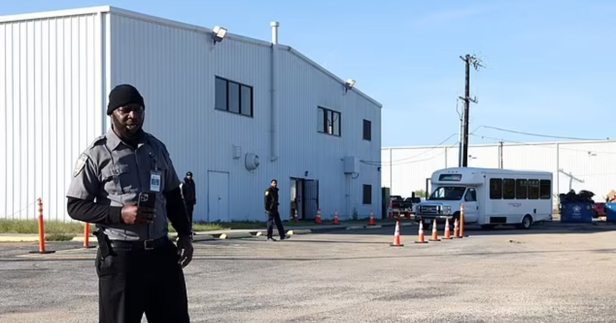 A security guard stands near a San Antonio airport hangar that houses illegal immigrants.