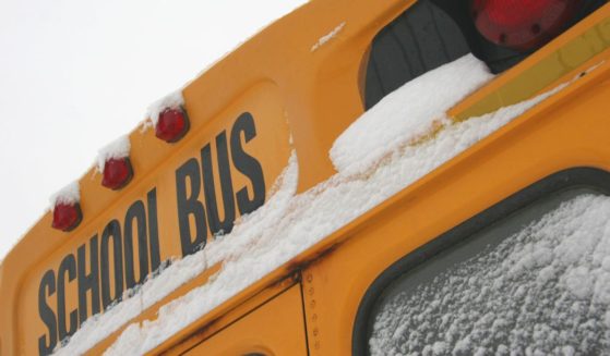 A stock photo shows a school bus with snow on the window.