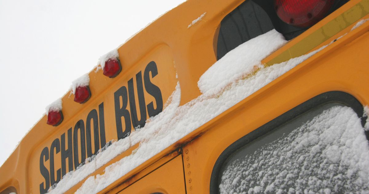 A stock photo shows a school bus with snow on the window.