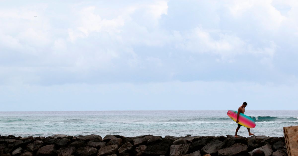 A surfer returns to Waikiki Beach in Honolulu.