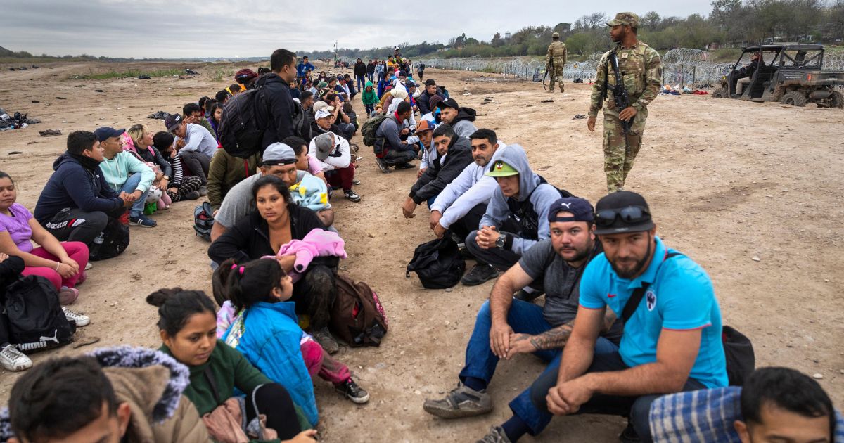 A Texas National Guard soldier counts a group of immigrants who had illegally crossed the U.S.-Mexico border on Wednesday in Eagle Pass, Texas.