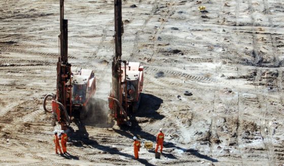 Two production drills complete a blast pattern while spotters observe at an open-pit copper mine in Zambia in this undated stock photo. On Saturday, seven miners were confirmed dead at a site in Chingola, Zambia.