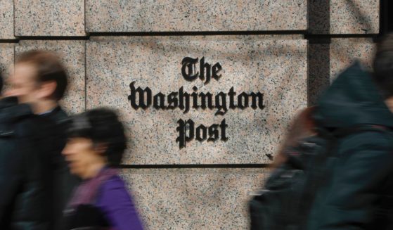 People walking by the home of The Washington Post newspaper