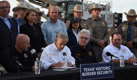 Texas Gov. Greg Abbott uses a border wall construction site in Brownsville, Texas, as a backdrop on Monday to sign bills that will broaden his border security plans and add funding for more infrastructure to deter illegal immigration.