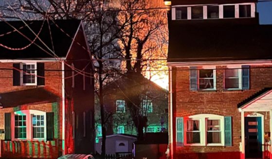 A home is seen exploding from a distance Monday night in Arlington, Virginia.
