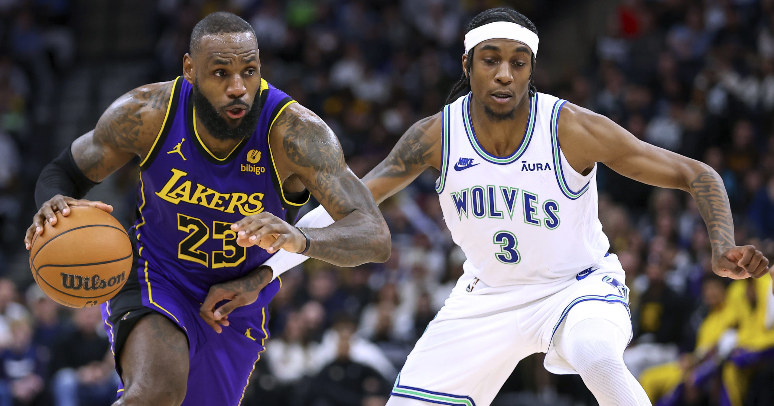 Los Angeles Lakers forward LeBron James, left, works towards the basket as Minnesota Timberwolves forward Jaden McDaniels defends during the second half of an NBA game Saturday, December 30, 2023 in Minneapolis, Minnesota.