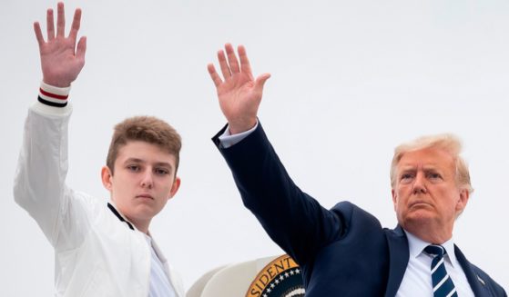 Then-President Donald Trump and his then-14-year-old son, Barron, wave as they board Air Force One at Morristown Municipal Airport in Morristown, New Jersey in an August 2020 file photo.