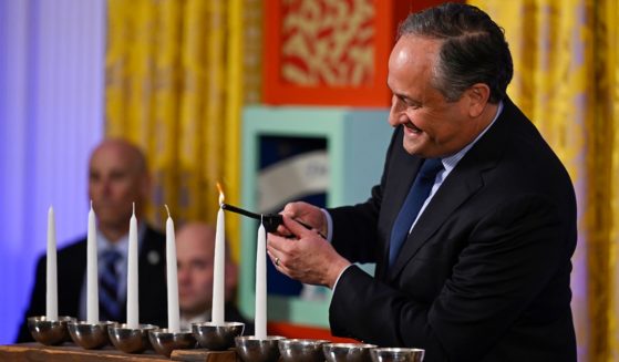 Doug Emhoff, husband of Vice President Kamala Harris, lights the first candle on a menorah at a Hanukkah reception in the East Room of the White House on Monday.