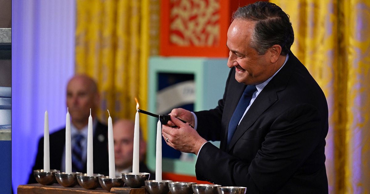 Doug Emhoff, husband of Vice President Kamala Harris, lights the first candle on a menorah at a Hanukkah reception in the East Room of the White House on Monday.