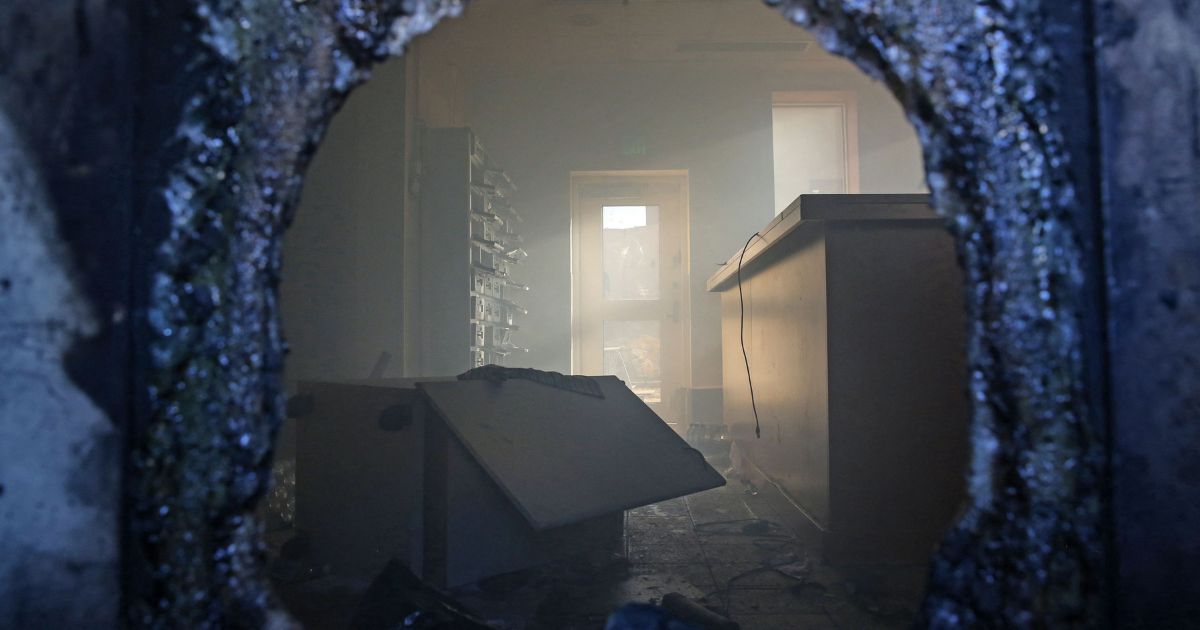 A picture taken through a broken window shows a vandalized room in the US embassy in Iraq's capital Baghdad, on December 31, 2019, after supporters and members of the Hashed al-Shaabi military network breached the outer wall.