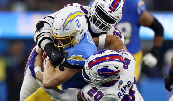Cam Lewis #39 and Taylor Rapp #20 of the Buffalo Bills tackle Easton Stick #2 of the Los Angeles Chargers during the third quarter at SoFi Stadium on Sunday in Inglewood, California.