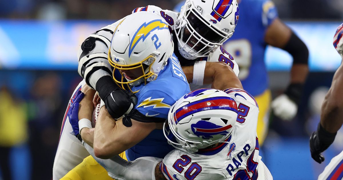 Cam Lewis #39 and Taylor Rapp #20 of the Buffalo Bills tackle Easton Stick #2 of the Los Angeles Chargers during the third quarter at SoFi Stadium on Sunday in Inglewood, California.