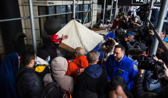 Migrants speak with NYC Homeless Outreach members as they camp out in front of the Watson Hotel after being evicted on Jan. 30 in New York City.