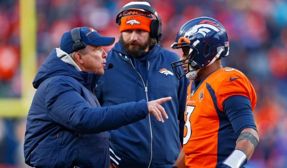 Denver Broncos coach Sean Peyton, left, talks with quarterback Russell Wilson during an October game with the Kansas City Chiefs in Denver.