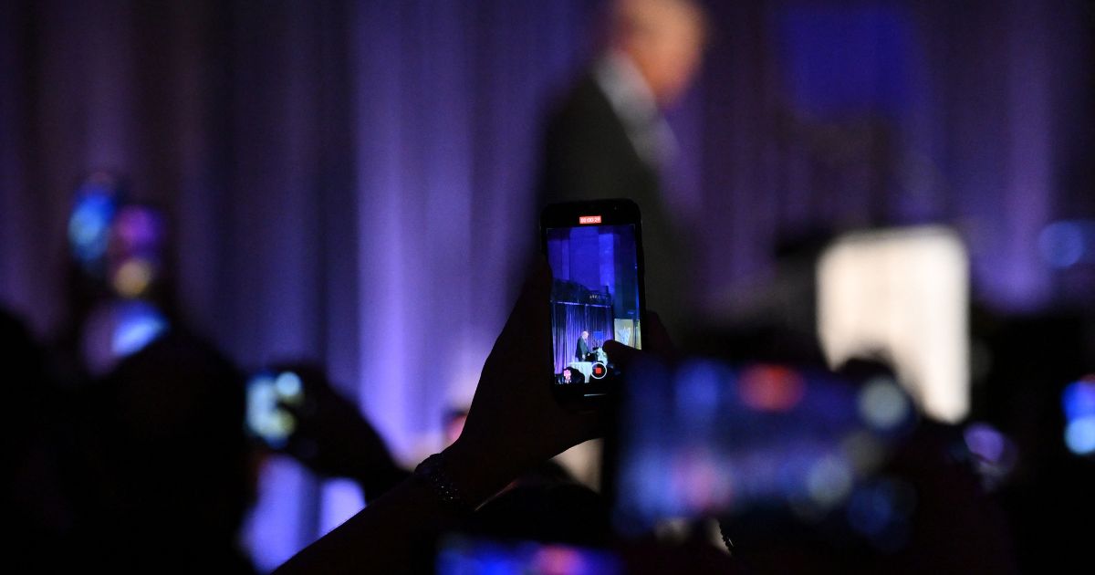 Attendees take pictures on their smartphones as former president and presidential hopeful Donald Trump speaks at the New York Young Republican Club's 111th annual gala in New York on Saturday.
