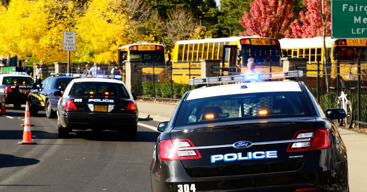 A stock photo shows police cars and school buses at the entrance of high school loading zone in Roseburg, Oregon, on Oct. 16, 2012.