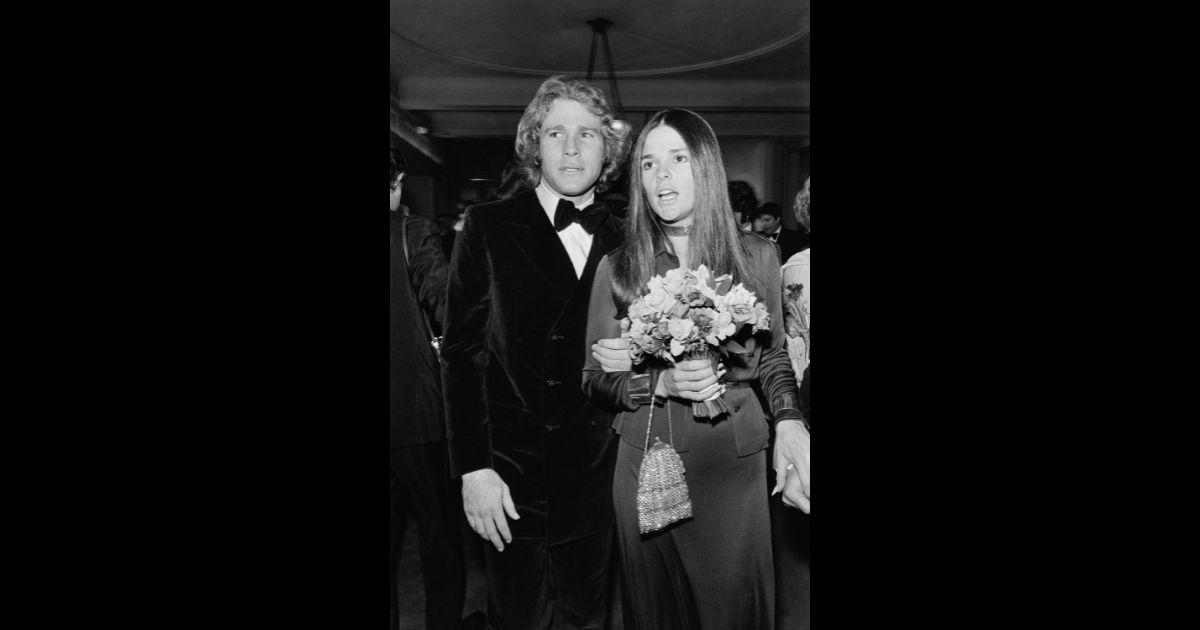 US actor Ryan O'Neal and US actress Ali MacGraw arrive to attend the premiere of the film "Love Story" directed by Arthur Hiller at the Theatre des Champs Elysees in Paris on March 19, 1971.