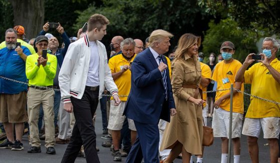 Former U.S. President Donald Trump, first lady Melania Trump and son Barron Trump are greeted upon return to the White House on August 16, 2020 in Washington, DC.