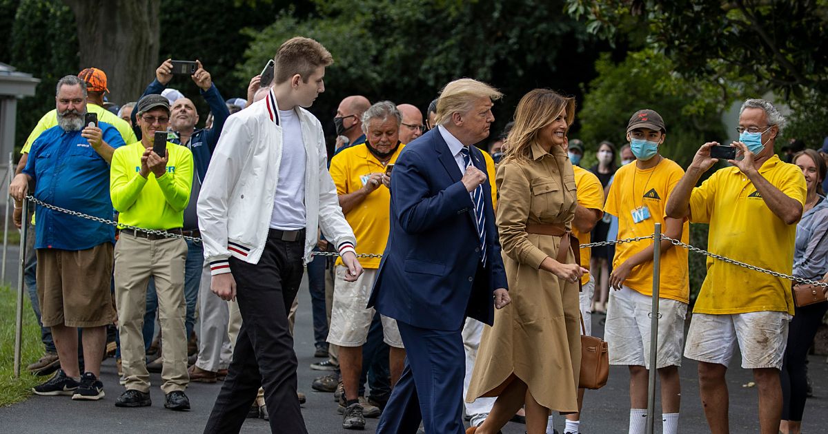 Former U.S. President Donald Trump, first lady Melania Trump and son Barron Trump are greeted upon return to the White House on August 16, 2020 in Washington, DC.