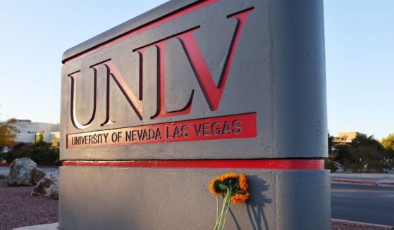 Flowers rest against a UNLV campus sign after a December 6 shooting left three dead at the University of Nevada, Las Vegas campus on December 7, 2023 in Las Vegas, Nevada.