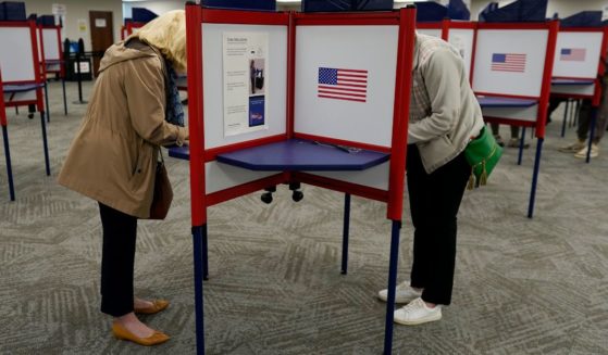 Voters stand in partitioned booths to fill out their ballots, Oct. 11, in Cincinnati.