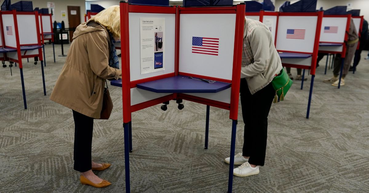 Voters stand in partitioned booths to fill out their ballots, Oct. 11, in Cincinnati.