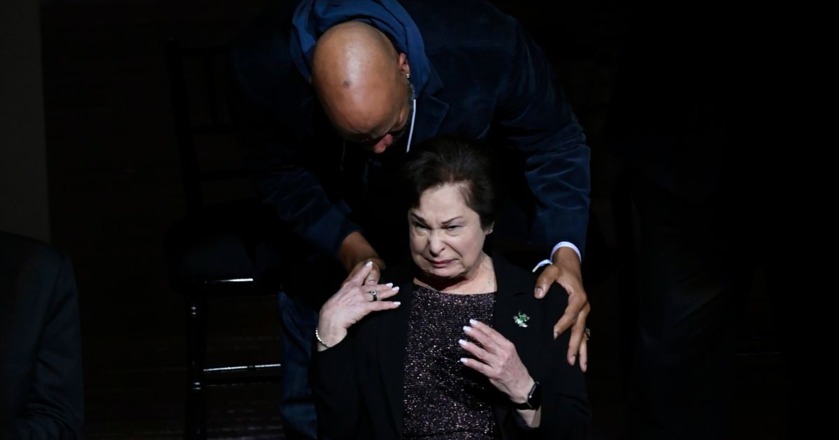Former Chicago Bulls player Ron Harper comforts Thelma Krause, widow of former Bulls general manager Jerry Krause, while the crowd boos when his name was announced during a Ring of Honor ceremony for the 1995-96 Bulls team, during halftime of an NBA basketball game between the Bulls and the Golden State Warriors on Jan. 12.