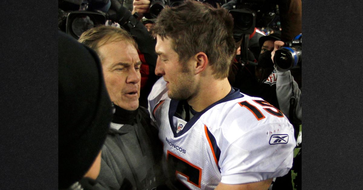 Tim Tebow, then a Denver Broncos quarterback, is seen hugging New England Patriots head coach Bill Belichick following an NFL divisional playoff football game in a file photo from Jan. 14, 2012.
