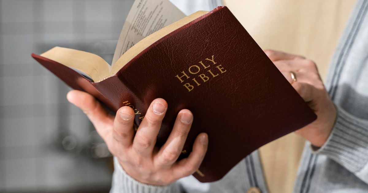 A stock photo shows a man holding and reading the Bible.
