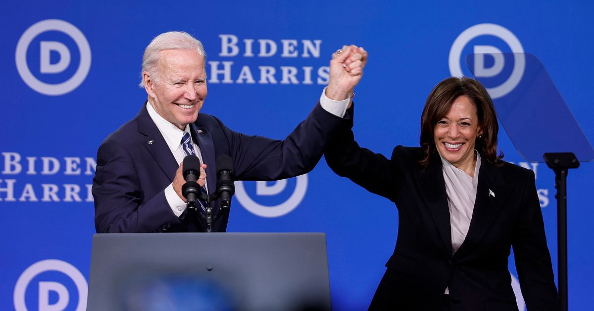 President Joe Biden and Vice President Kamala Harris hold hands onstage after speaking at the Democratic National Committee winter meeting in Philadelphia on Feb. 3, 2023.