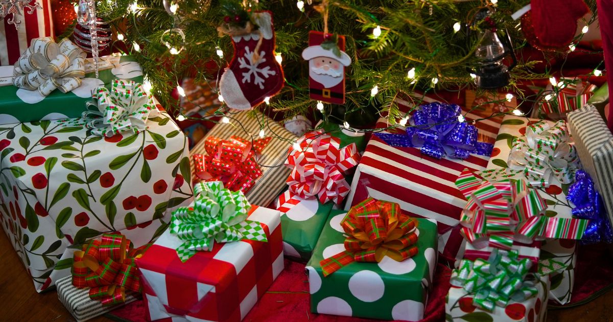 A stock photo shows wrapped presents under a Christmas tree.