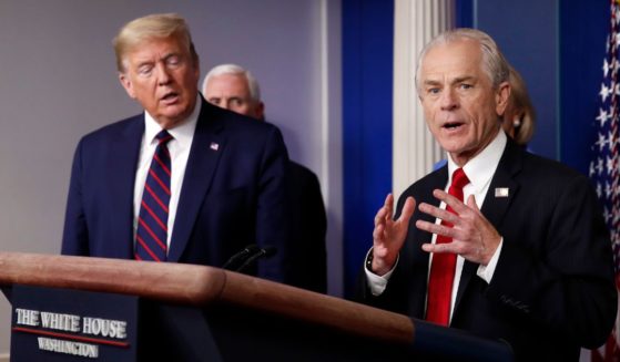 Former President Donald Trump, left, listens to former White House adviser Peter Navarro as he speaks to reporters in the James Brady Press Briefing Room in Washington, March 27, 2020.