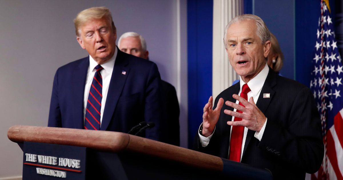 Former President Donald Trump, left, listens to former White House adviser Peter Navarro as he speaks to reporters in the James Brady Press Briefing Room in Washington, March 27, 2020.