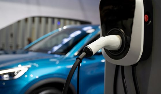 An electric vehicle charges in a stock photo
