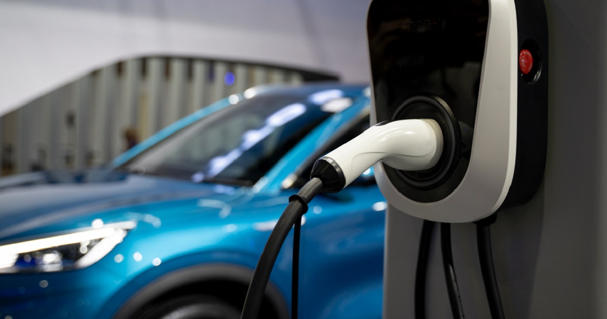 An electric vehicle charges in a stock photo