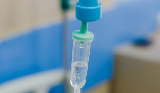 A stock photo shows a generic IV drip in a hospital room.