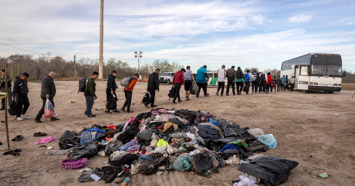 Illegal immigrants wait to load onto a U.S. Customs and Border Protection bus after crossing the U.S.-Mexico border in Eagle Pass, Texas, on Jan. 7. Over 2.3 million people have crossed illegally into the United States under the Biden Administration.