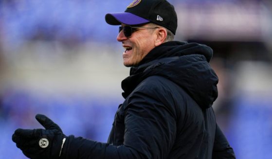 Michigan head coach Jim Harbaugh walks the field before Saturday's NFL football AFC divisional playoff game between the Baltimore Ravens and the Houston Texans in Baltimore.